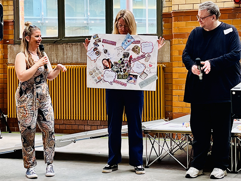 Attendees of the hackathon presenting a poster at the event